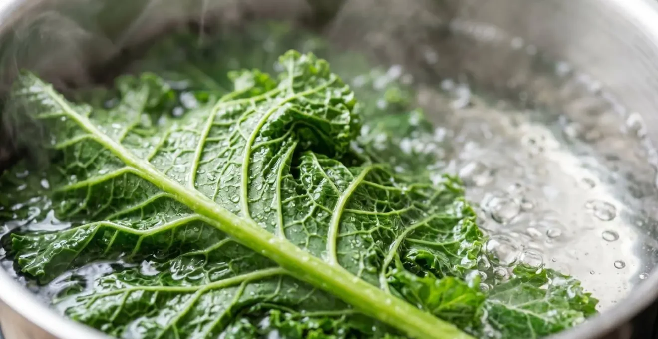 Close-up of vibrant green kale leaves being blanched in boiling water with steam rising