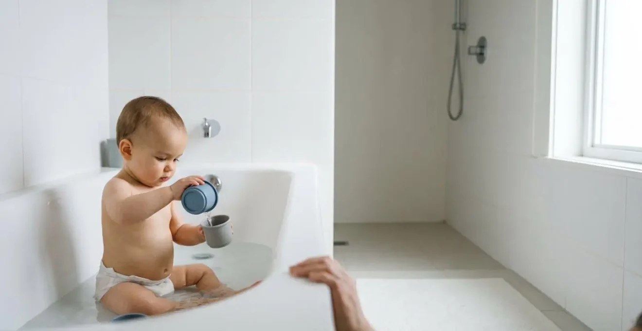 Baby practicing supervised water play with developmentally appropriate containers